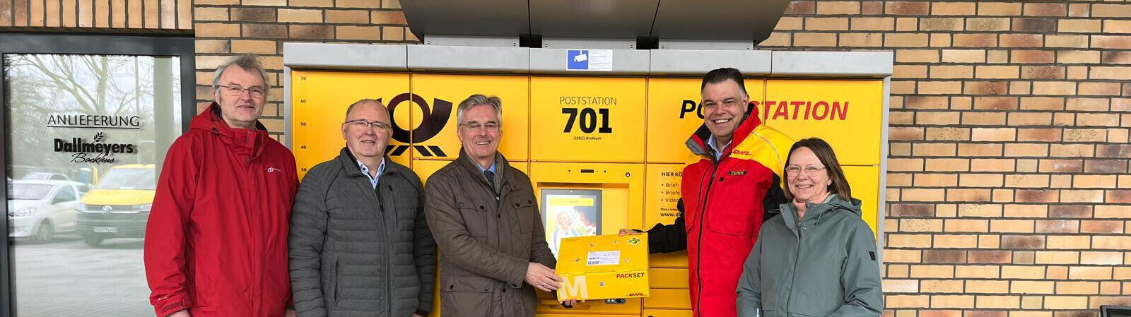 Gemeindevertreter und ein Mitarbeiter der Post präsentieren die neue Poststation