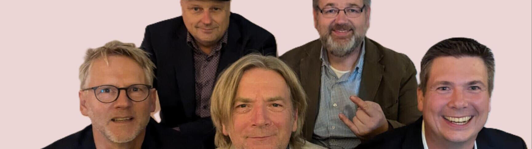 Die Mitglieder der Band sitzen nebeneinander