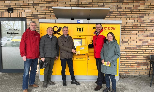 Gemeindevertreter und ein Mitarbeiter der Post präsentieren die neue Poststation